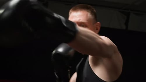 Muscular Man Boxing and Punching in Gym
