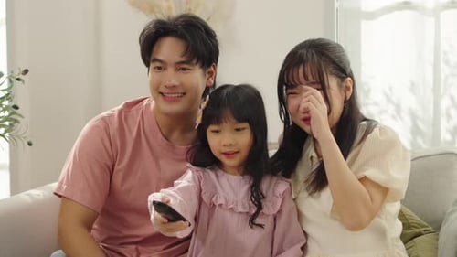 Happy Family Watching TV Together at Home