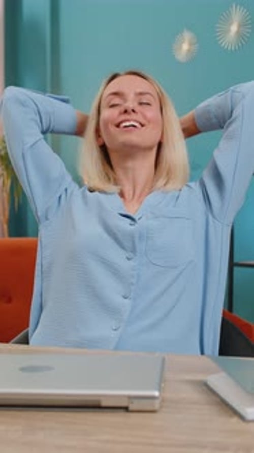 Happy Woman Closes Laptop and Stretches in Home