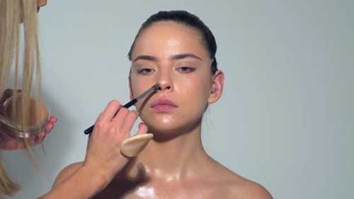 Professional Makeup Artist Working with Beautiful Young Woman Close Up Makeup for Young Model Makeup