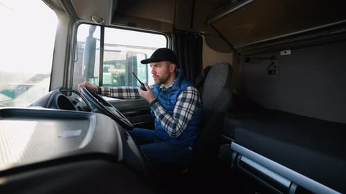 Truck Driver Communicating Via Walkietalkie in Righthand Drive Truck Before Trip