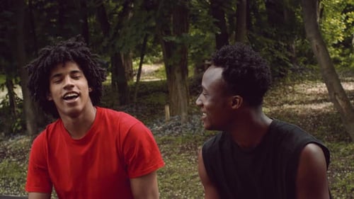 Men Enjoying Conversation Outdoors While Exercising in Public Park