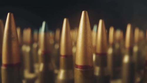 Filas de cartuchos para un rifle sobre fondo negro Primer plano Munición de tornillo envueltas en nubes de
