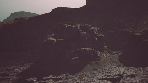 Massive Rock Formation With Mountain in Background