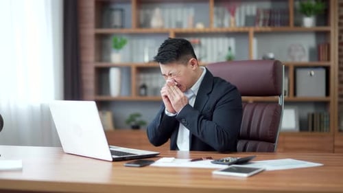 Man in Suit Sick in Office with Tissue