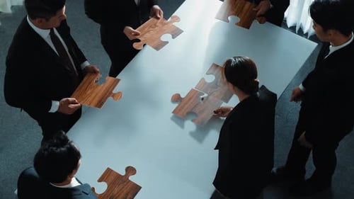 Top view of businesspeople putting jigsaw together at meeting room. Directorate.