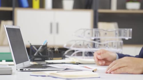 Man Reviews Business Charts in Office Setting