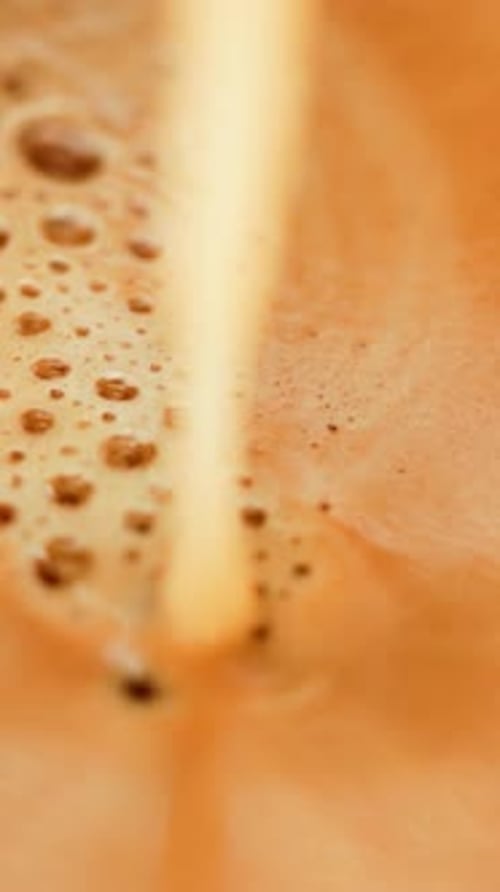 Beige liquid pours into beige pool