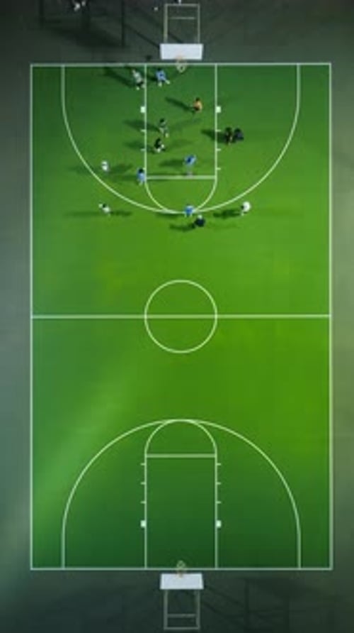 Aerial View of Basketball Game on a Green Court with Players Competing in an Evening Match