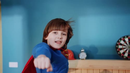 Smiling Child Superhero with Cape Indoors