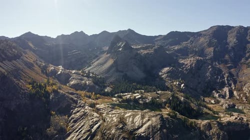 Wide aerial drone shot of Lake Blanche in Utah’s Big Cottonwood Canyon. The camera dollies in, towar