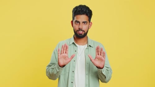Man Gesturing with Hands on Yellow Background