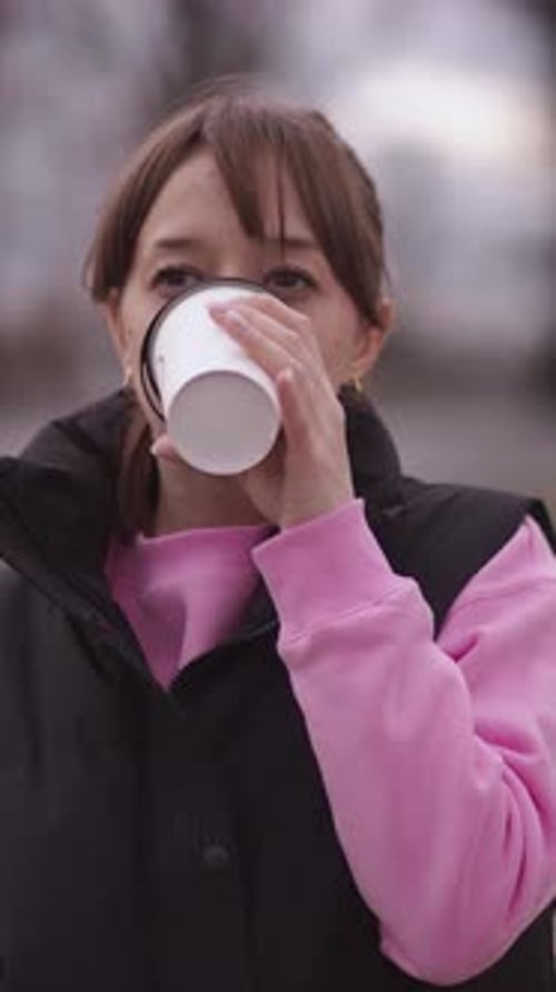 Young woman enjoying a hot beverage outdoors