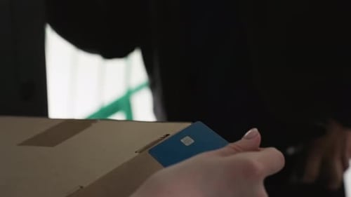 Delivery Transaction Visual Courier Scans Card at Doorstep Closeup of Courier Using Contactless