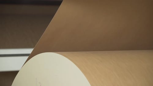 Große Rolle glattes Papier, das in einer Fabrik gedreht wird. Nahaufnahme