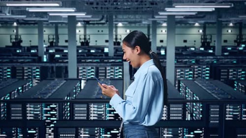 Side View Of Asian Business Woman Using Mobile Phone In Data Center