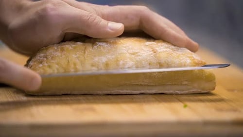 Cutting a loaf of bread in half.