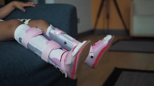 Child Wearing Orthopedic Braces at Home During Therapy Session