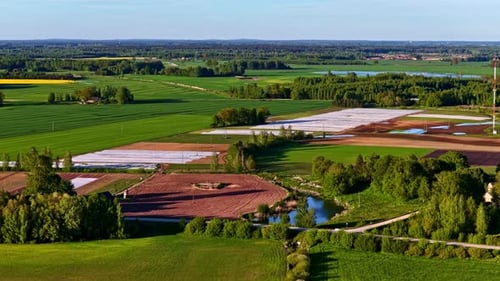 Eine grüne Landschaft mit Feldern und einem See.