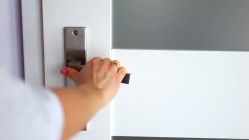 Woman's Hand Opening a White Door