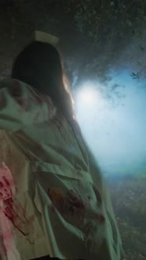 Woman in Bloody Nurse Costume Running at Night