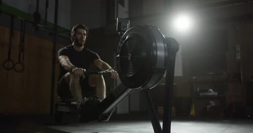 Extreme Atheltics - Male rower training in gym on machine