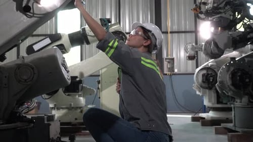 Female engineer at factory. Smart Industry Robot Arms Modernization for Digital Factory Technology