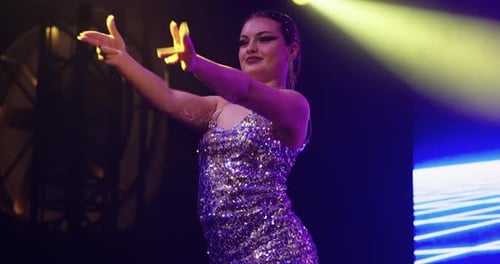 Retrato de una atractiva dama bailando en el escenario bailando de respaldo en un concierto musical, bailarina profesional