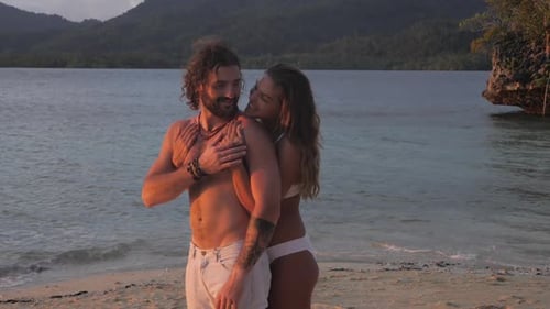 A young couple hugging with love on a romantic holiday or vacation at a tropical beach or island