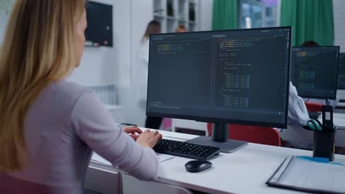Grupo de profesionales de TI en la oficina viendo una computadora con Program Code Woman escribiendo nuevos programas