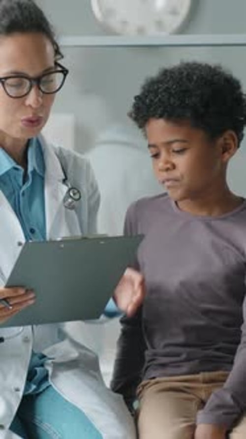 Doctor Consults with Young Patient in Hospital