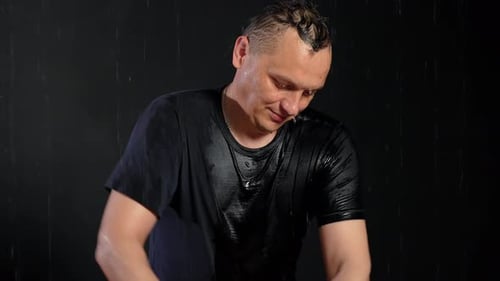 Homem molhado na zona aquática massageando uma cliente feminina em um ambiente descontraído. Gotas de água escorrem pelo rosto