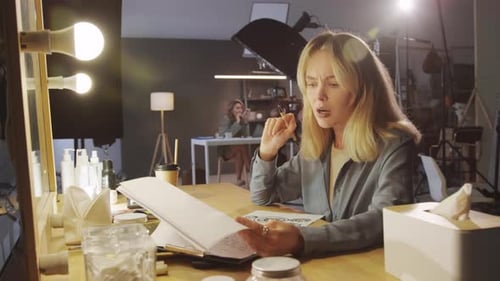 Female Producer Looking at Storyboard and Script in Studio