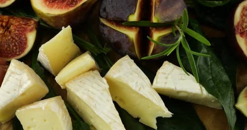 Figues, jamons, feuilles d'épinard, raisins et fromages bleus sur une planche de bois. Set de snacks.