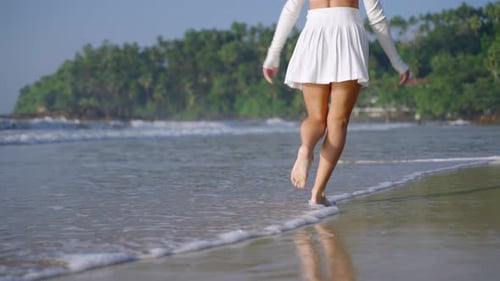 Female Feet Running and Jumping in Sea Surf Waves Making Splashes of Water Model Walking Along Sandy