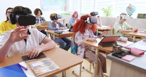 Interactive School Concept Kids in VR Headsets Sitting at Desks and Having Virtual Reality Learning