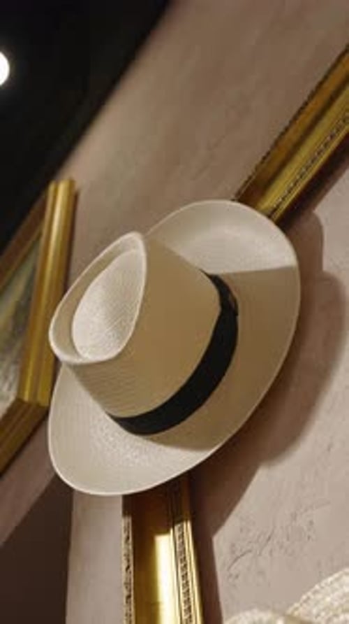 Vertical - vintage hat hang on golden painting frame on wall, Czechia