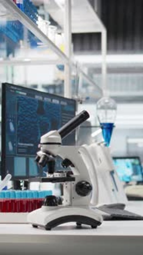 Microscope in Modern Medical Laboratory with Test Tubes