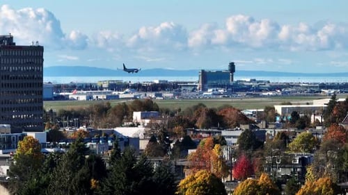 Airplane Landing On Runway Of YVR Airport In Richmond, BC, Canada. Autumn Colors In Foreground. aeri
