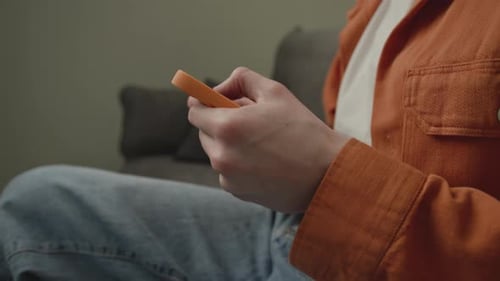 Man Playing Video Game Using Cellphone Close Up Man with Smartphone on Couch Handheld Camera