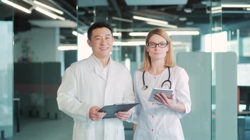 portrait friendly two smiling happy doctors looking at camera in a hospital. Group asian medic man