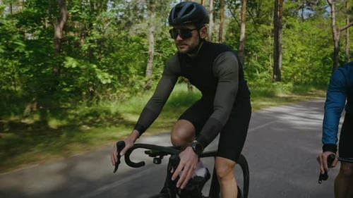 Men Cyclists in Activewear Ride Bicycles Along Country Track
