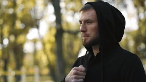Man in Black Hoodie Outdoors Looks to the Side