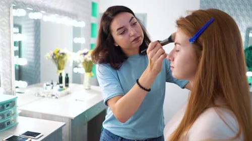 Makeup Artist Applies Cosmetics to Model in Studio