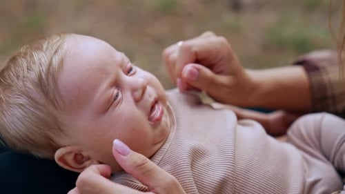 Loving Hands Gently Caressing a Happy Infant