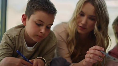Family Drawing Pictures on Floor Indoors Together