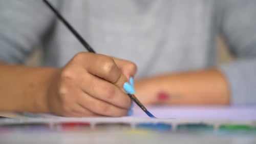 Close Up Female Hand Colouring with Blue Watercolor 4K