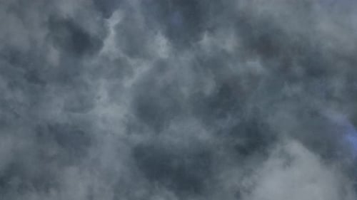 Der Aussichtspunkt nähert sich den dicken dunklen Wolken mit einem Gewitter, das aufblitzt.