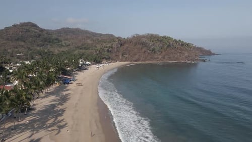 Aerial view of quiet sandy beach palm trees at Pacific Lo de Marcos MX