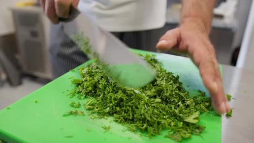 Chef Is Chopping Parsley With Knife On A Green Chopping Board